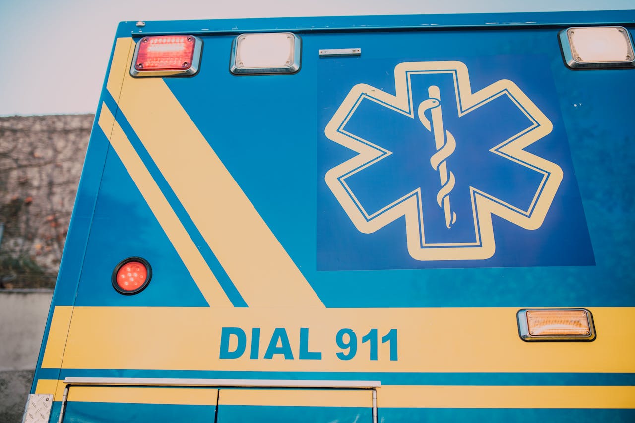 Close-up of an ambulance with star of life symbol and 'Dial 911' text.