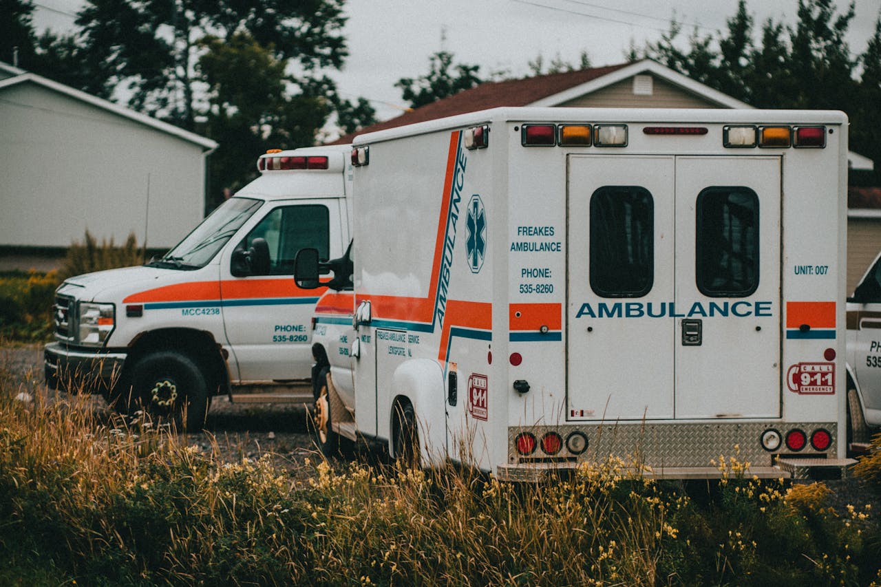 Two ambulances parked in a rural setting, ready for emergencies.